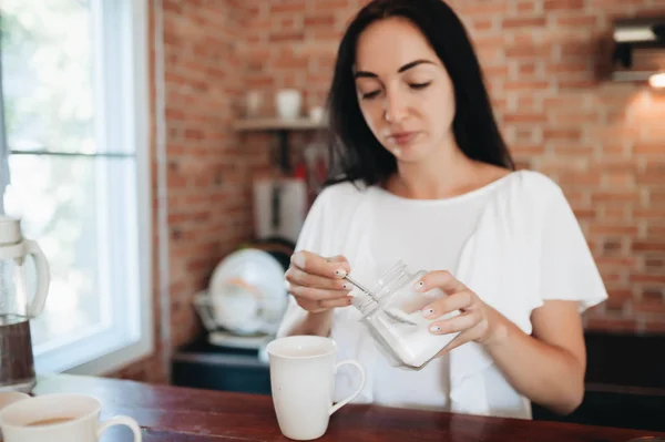 Jong gelukkig vrouw drinken koffie op de keuken in de ochtend. — Stockfoto