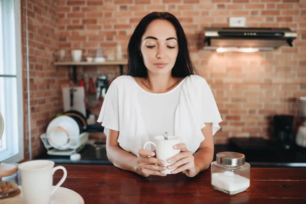 Jong gelukkig vrouw drinken koffie op de keuken in de ochtend. — Stockfoto