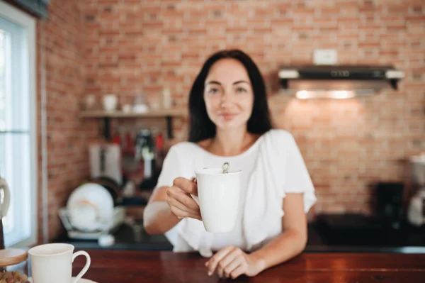 Jong gelukkig vrouw drinken koffie op de keuken in de ochtend. — Stockfoto