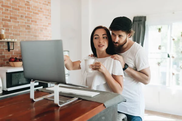 Gelukkige jonge paar met laptop thuis — Stockfoto