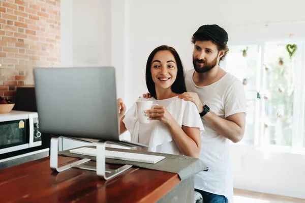 Gelukkige jonge paar met laptop thuis — Stockfoto