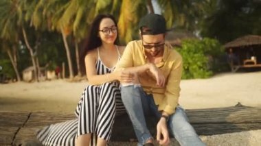 Sahilde günlük oturan genç çift günbatımı zevk