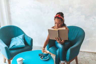 Kafede kitap okuyan güzel bir kadın.