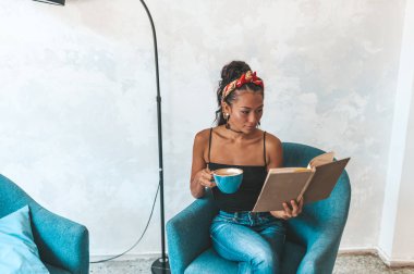 Kafede kitap okuyan güzel bir kadın.