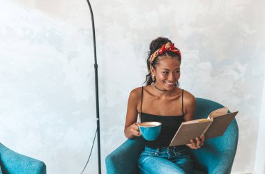 Kafede kitap okuyan güzel bir kadın.