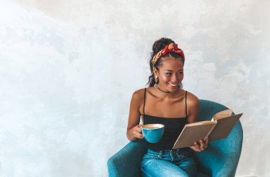 Kafede kitap okuyan güzel bir kadın.