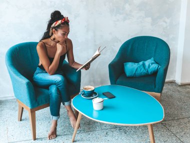 Kafede kitap okuyan güzel bir kadın.