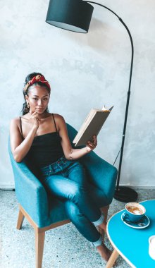 Kafede kitap okuyan güzel bir kadın.