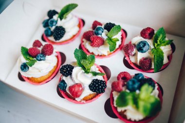 Kek kutusunda krema, çilek ve miny ile dekore.