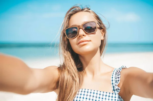 Piękna młoda kobieta robi selfie na plaży — Zdjęcie stockowe