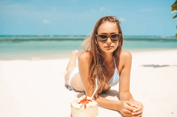 Ung vacker kvinna dricker kokos vatten på tropiska stranden — Stockfoto