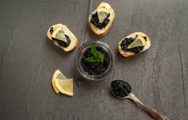 Siyah zemin üzerinde havyar ile siyah mersin balığı havyar ve kanepekavanoz