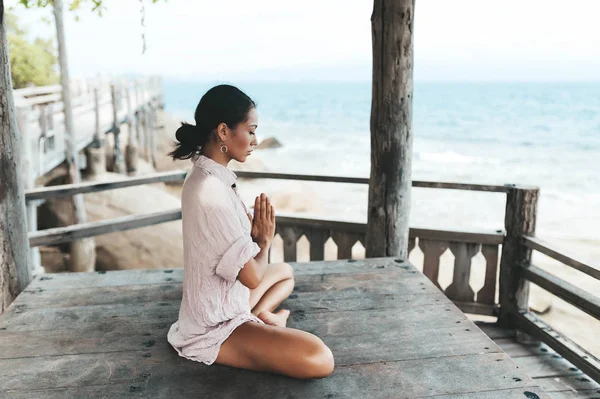 Plajda yoga pozu veren genç kadın — Stok fotoğraf