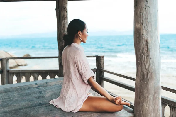 Młoda kobieta medytuje w Joga pozowanie na plaży — Zdjęcie stockowe