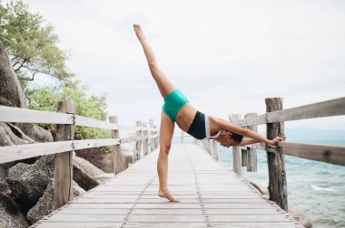 Ahşap köprü yoga yaparken genç kadın