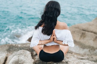 Genç kadın taşlar üzerinde yoga yapıyor