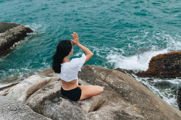 Genç kadın taşlar üzerinde yoga yapıyor — Stok fotoğraf