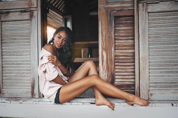 Kafede pencere deliğinde oturan gömlek giyen genç kadının moda portresi