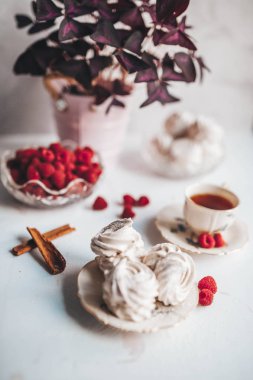 Ham ahududu ve beyaz bir masada tee bir fincan plaka üzerinde ev yapımı Marshmallow zephyr Natürmort.