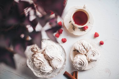 Ham ahududu ve beyaz bir masada tee bir fincan plaka üzerinde ev yapımı Marshmallow zephyr Natürmort.