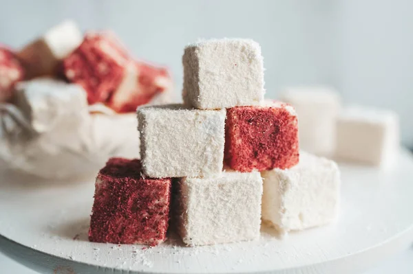 Homemade candy bird\'s milk with coconut and cranberry sprinkling on white background