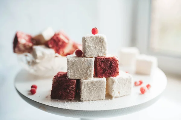 Homemade candy bird\'s milk with coconut and cranberry sprinkling on white background