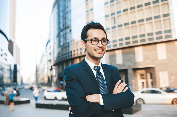 Modern businessman in full suit standing outdoors with cityscape in the background — Stock Photo, Image