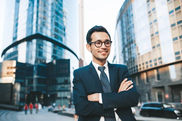 Modern businessman in full suit standing outdoors with cityscape in the background — Stock Photo, Image