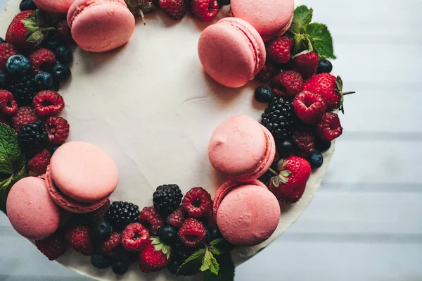 Cake decorated with macaroons and berries — Stock Photo, Image
