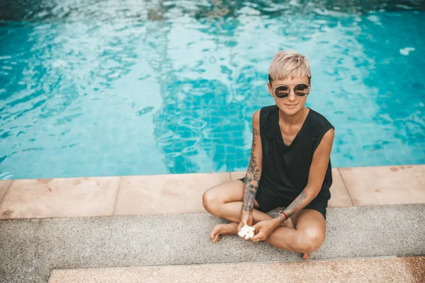 Vrouw Blond Zitten Aan Het Zwembad Ruiken Een Bloem Frangipani — Stockfoto