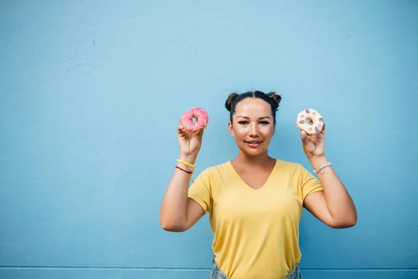 Щасливий Портрет Дівчини Жовтій Футболці Їсть Пончики Синій Стіні — стокове фото