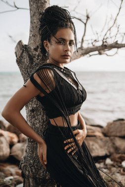 Mısır tarzı örgülü bir kadın portresi sahilde poz veriyor.