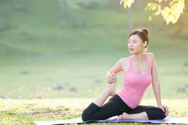 Genç güzel Asyalı kadın bahçede Yoga uygulamak