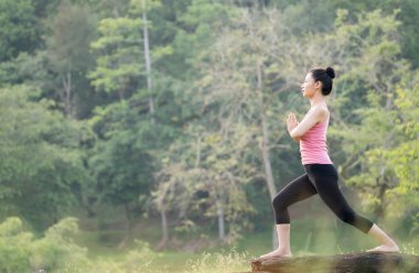 Genç güzel Asyalı kadın bahçede Yoga uygulamak