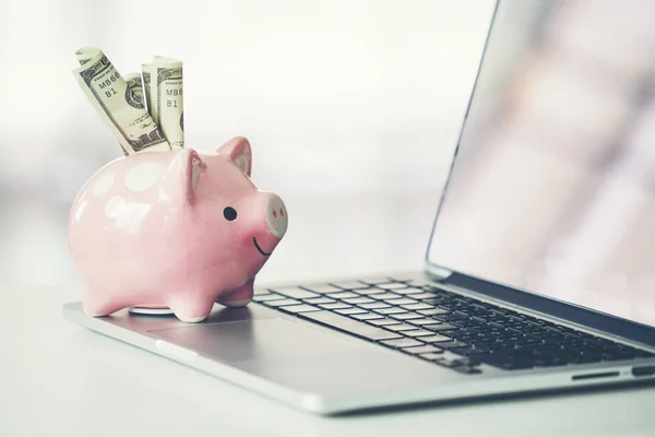Piggy bank with laptop on the desk — Stock Photo, Image