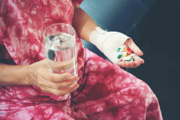 Kıdemli asyalı kadın elinde hap ilaç almak — Stok fotoğraf