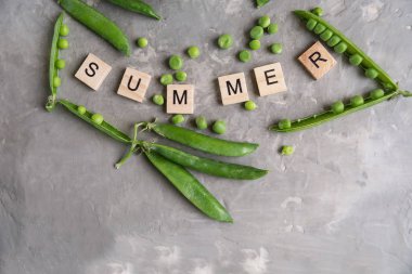 Organik yeşil bezelye ve kelime yaz gri taş zemin üzerine.