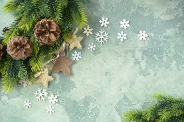 Noel kartı. Yeşil taş arka plan üzerinde yıldız. Üstten görünüm. Uzay kopyalayın. Düz yatıyordu. Noel kavramı. Tatil arka plan. Kar taneleri ve ahşap yıldız, çam kozalağı ağaç dalları üzerinde.