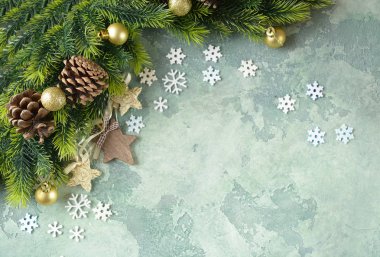 Noel kartı. Yeşil taş arka plan üzerinde yıldız. Üstten görünüm. Uzay kopyalayın. Düz yatıyordu. Noel kavramı. Tatil arka plan. Kar taneleri ve ahşap yıldız, çam kozalağı ağaç dalları üzerinde.