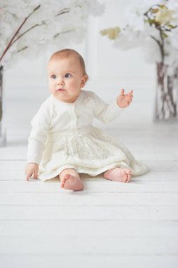 Katta oturan sevimli on aylık toddler bebek kız. Uzay kopyalayın. yalınayak alt kat ganimet üzerinde oturur