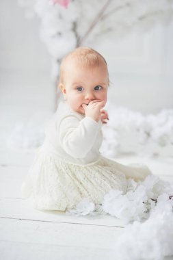 Katta oturan sevimli on aylık toddler bebek kız. Uzay kopyalayın. yalınayak alt kat ganimet üzerinde oturur