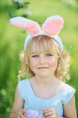 Paskalya yumurtaları ve tavşan kulakları Garden ile şirin komik kız. Paskalya kavramı. Paskalya yumurtası avı gülen çocuk. Çocuk Parkı yumurta, bahar kavramı ile