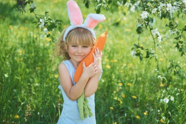 Paskalya yumurtaları ve tavşan kulakları Garden ile şirin komik kız. Paskalya kavramı. Paskalya yumurtası avı gülen çocuk. Çocuk Parkı yumurta, bahar kavramı ile