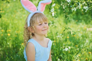 Paskalya yumurtaları ve tavşan kulakları Garden ile şirin komik kız. Paskalya kavramı. Paskalya yumurtası avı gülen çocuk. Çocuk Parkı yumurta, bahar kavramı ile