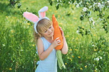 Paskalya yumurtaları ve tavşan kulakları Garden ile şirin komik kız. Paskalya kavramı. Paskalya yumurtası avı gülen çocuk. Çocuk Parkı yumurta, bahar kavramı ile