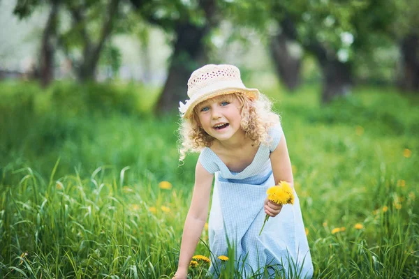 女孩收集蒲公英花束在果园的草地上的花圈 美丽的微笑的小女孩在阳光明媚的日子在外面玩耍 孩子在春天的花朵中绿草中 过敏季节 — 图库照片