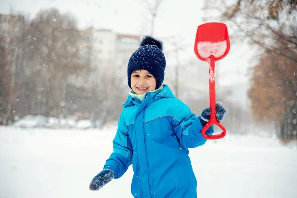 有趣的小男孩玩雪 孩子用铲子在冬天散步 孩子们在外面玩 冬季有趣的概念 — 图库照片