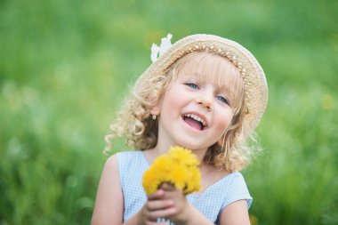 Küçük kız bir karahindiba koklama. Elma bahçesi çiçek koklama kız. Bahçe çiçekli ağaçlar ile. Mutlu çocukluk. Anti sezon, böcekler. Kız dandelions buket çelenk orchard, çayırda için toplar.