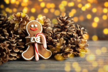 Çam kozalakları ahşap masa arka plan üzerinde yakınındaki zencefilli kurabiye adam. Noel ve yeni yıl kompozisyon. kopya alanı. Noel ve yeni yıl kompozisyon. Noel kartı