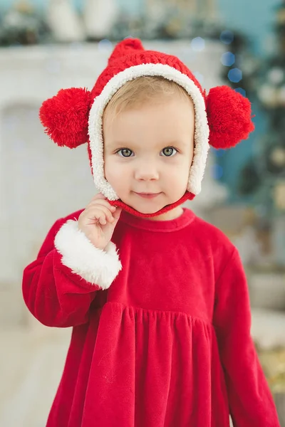 赤いクリスマス衣装装飾立ちながらカメラ目線の少女ぼやけてルーム — ストック写真